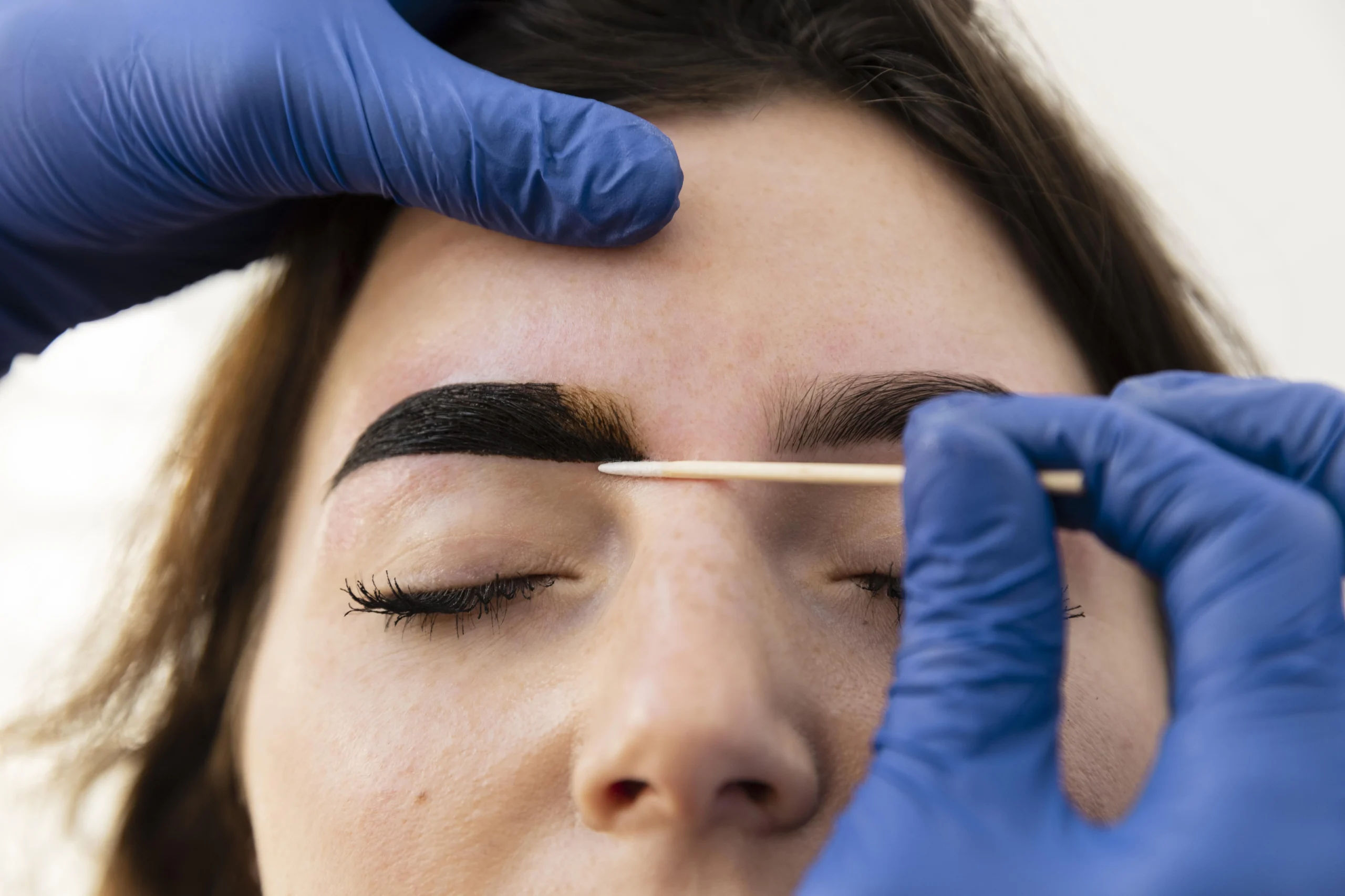 woman-getting-eyebrow-treatment-from-beautician